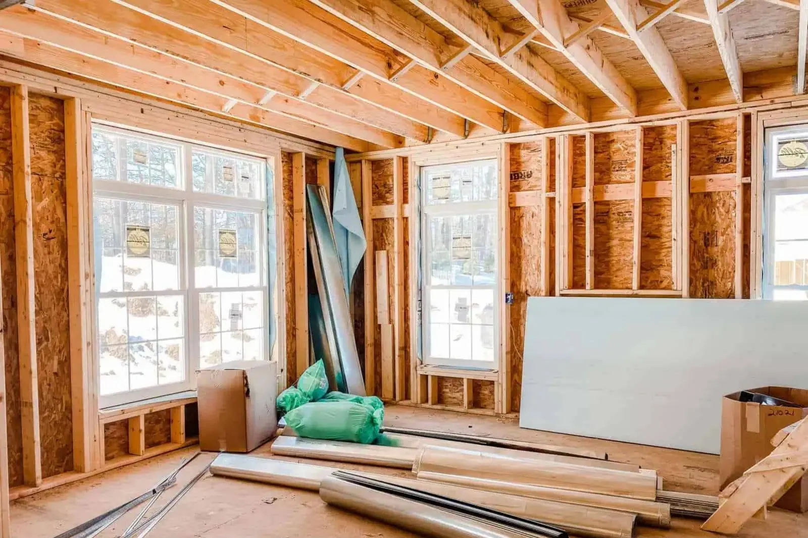 Holzständerwerk mit Fenstern und Dämmmaterial vor dem Innenausbau
