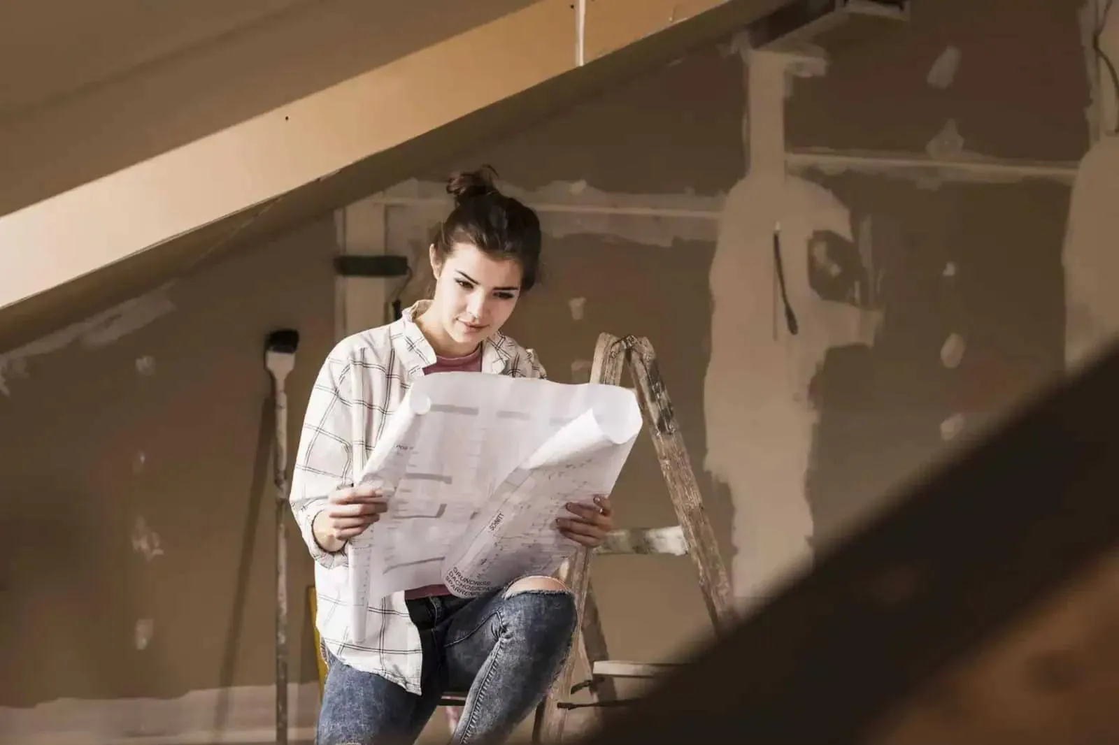 Planung einer Renovierung im Dachgeschoss mit Bauplan vor verspachtelter Wand